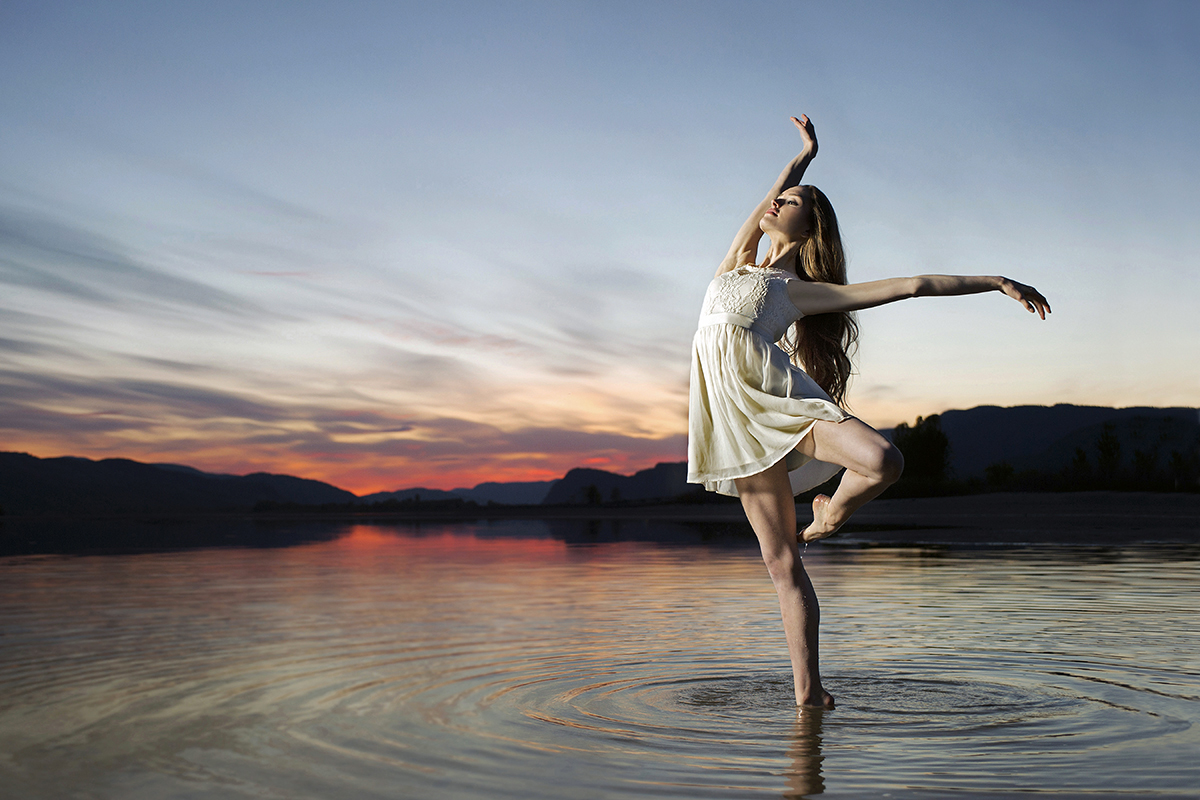 A young ballet dancer strikes a pose during a beautiful sunset on the Thompson river, west of Kamloops, Thompson Okanagan region, British Columbia, Canada