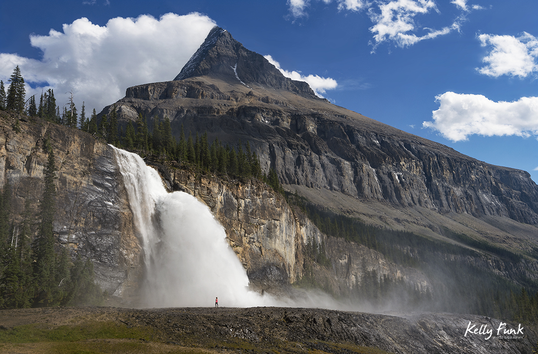 A hiker enjoys the mist from the mighty Emperor Falls, Mt. Robson Provincial Park, Canadian Rockies, British Columbia