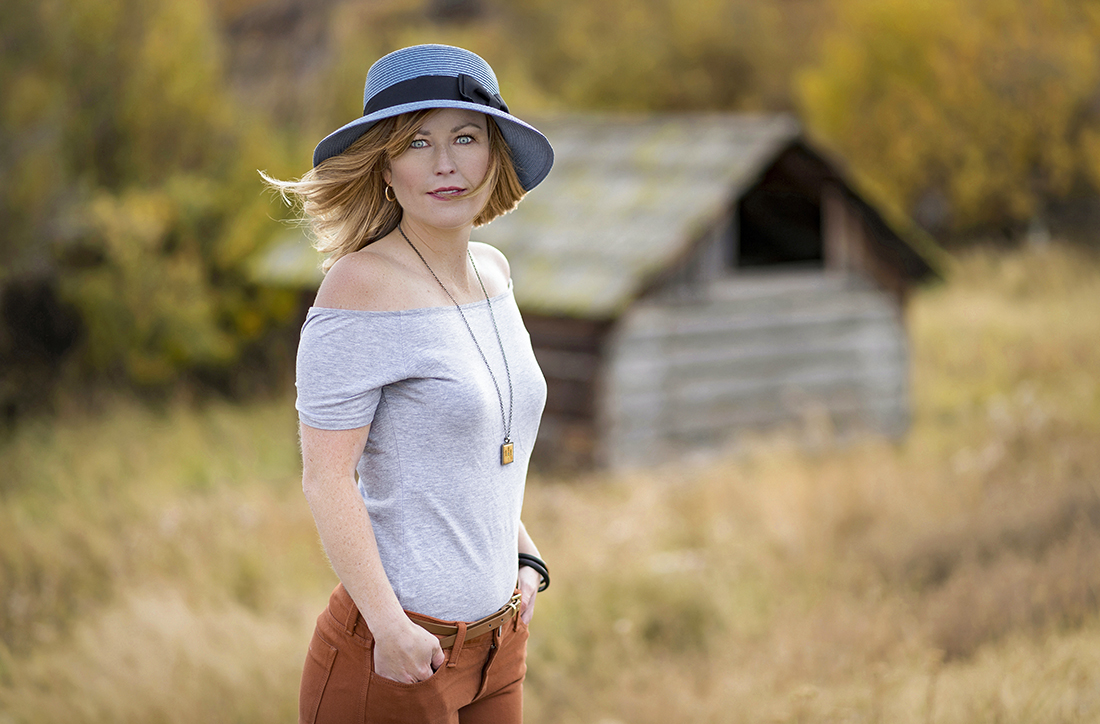 A young woman with blue eyes poses for a portrait on a beautiful fall day near Kamloops, British Columbia, Canada, Thompson Okanagan region