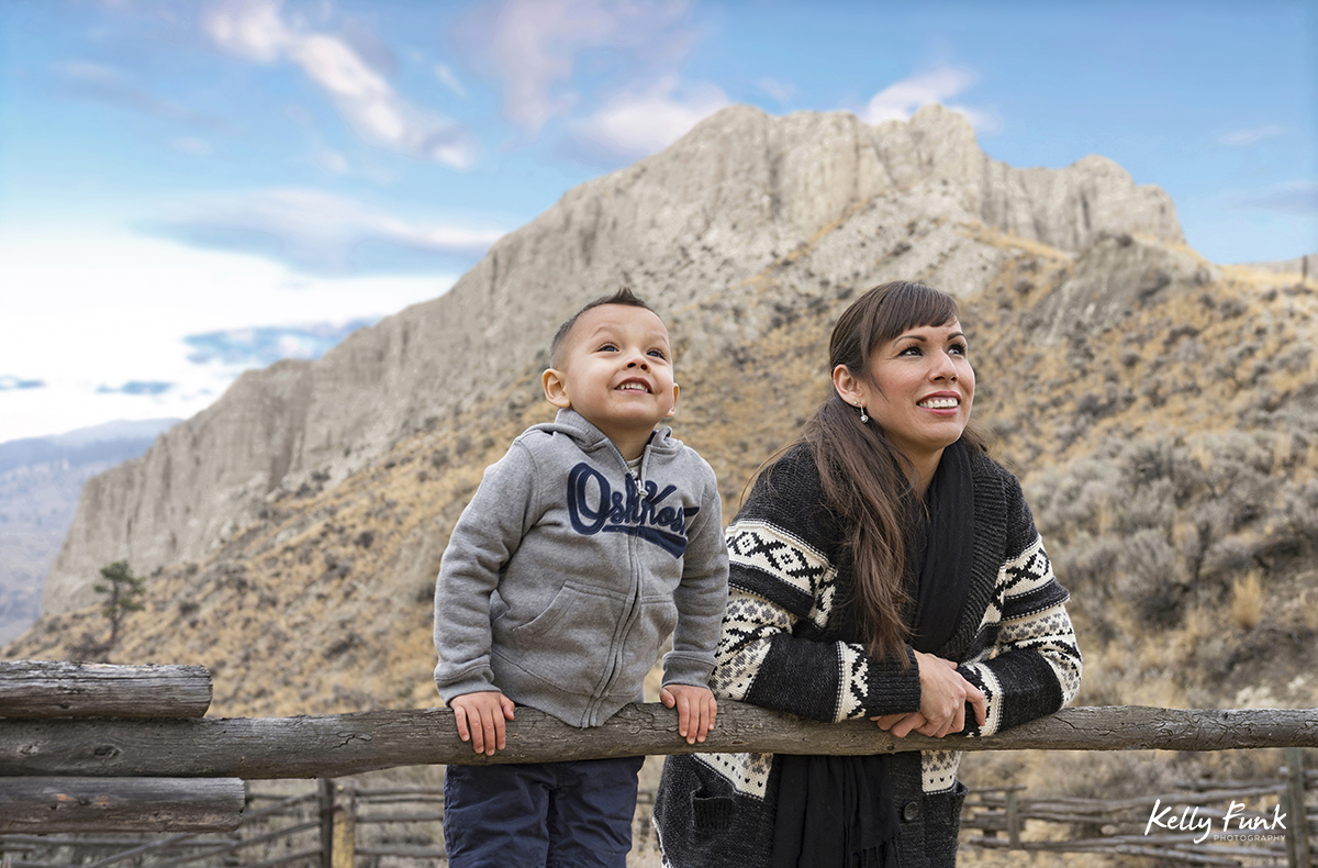 A mother looks skyward with her smiling son during a family shoot, near Kamloops, British Columbia, Canada