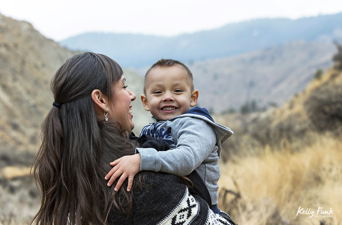 A mother holds her smiling son during a family shoot, near Kamloops, British Columbia, Canada