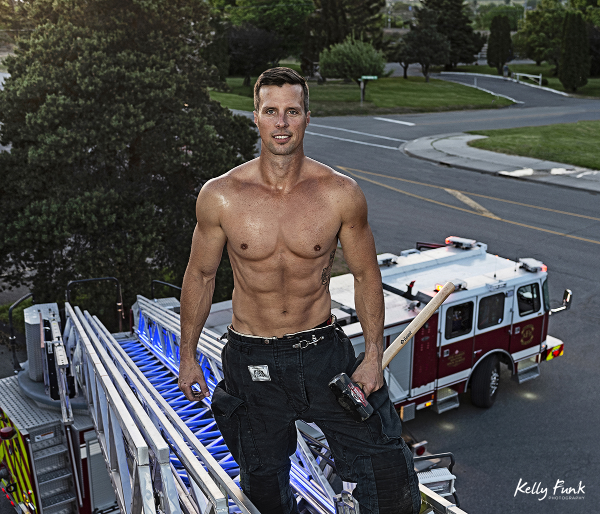 a good looking fire fighter poses for a commercial portrait during shooting for the 2019 Kamloops fire fighters calendar, Thompson Okanagan region, British Columbia, Canada