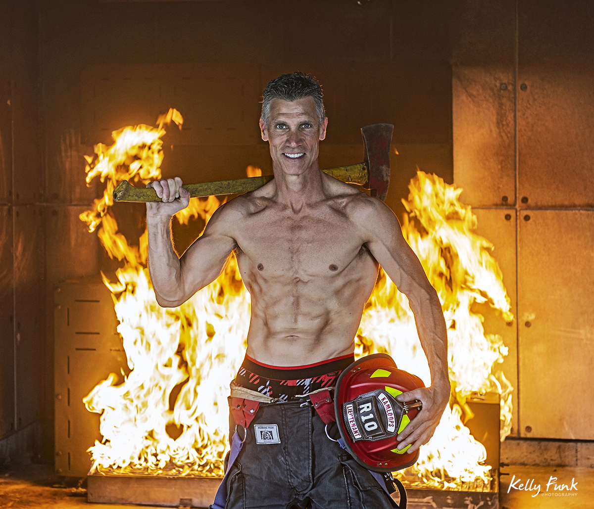 a good looking fire fighter poses for a commercial portrait during shooting for the 2019 Kamloops fire fighters calendar, Thompson Okanagan region, British Columbia, Canada