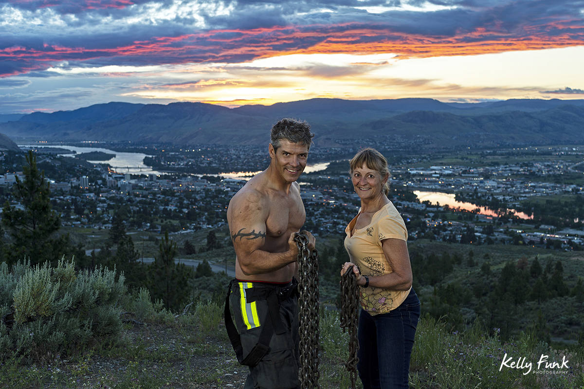 A technical photography assistant and a fire fighter pose during shooting for the 2019 Kamloops fire fighters calendar, Thompson Okanagan region, British Columbia, Canada