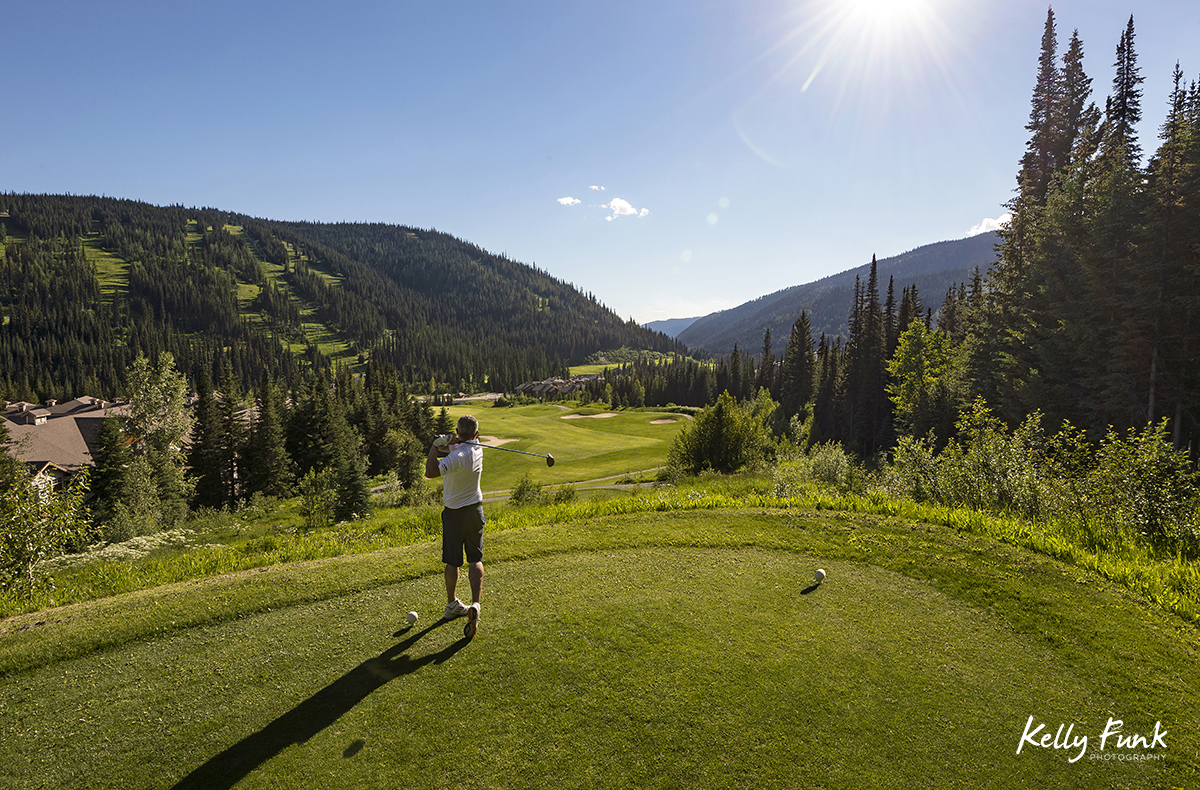 A man tees off at the elevated 16th hole at the Sun Peaks Resort golf course, north east of Kamloops, British Columbia, Thompson Okanagan region, Canada