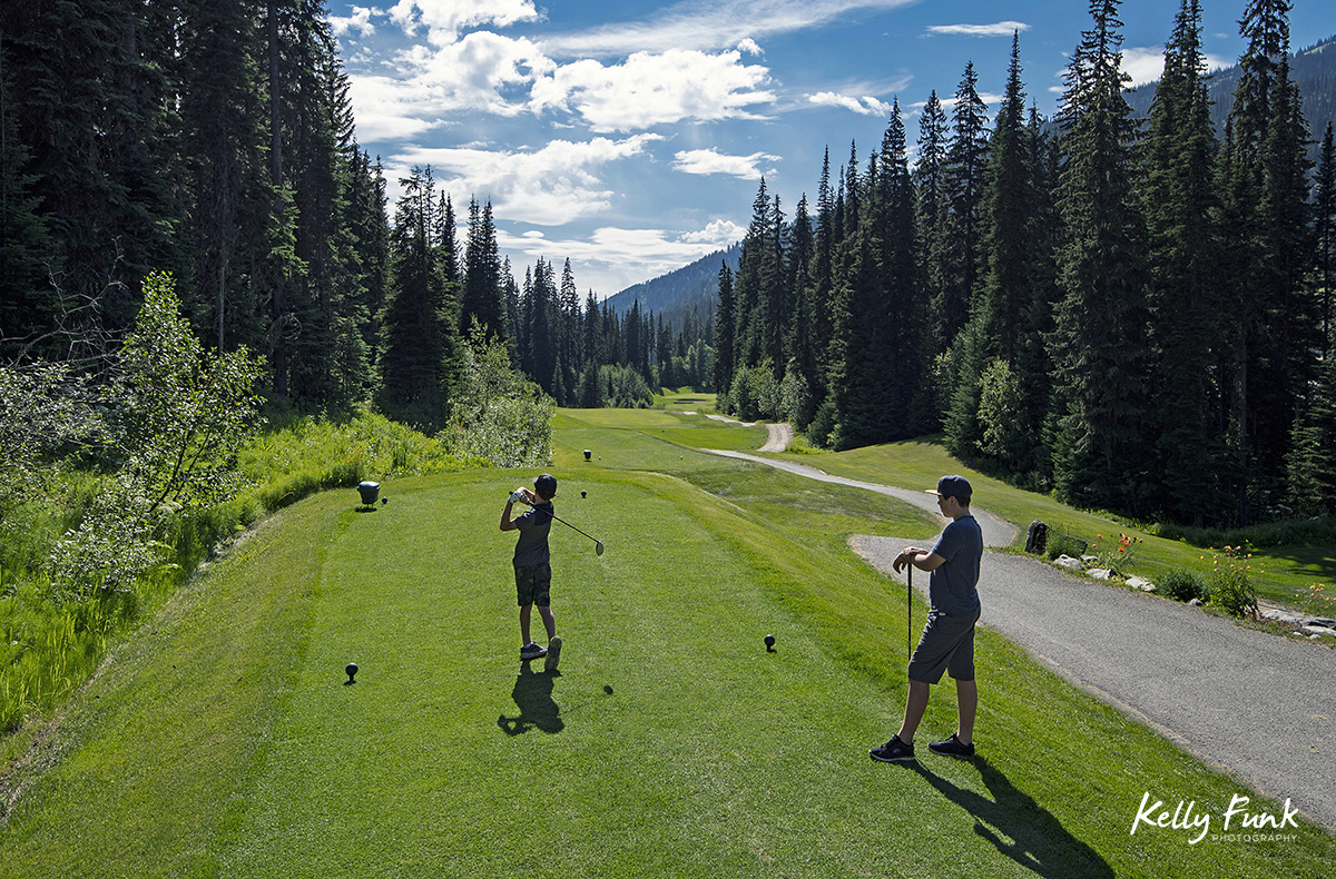 Two boys tee off at the Sun Peaks Resort golf course, north east of Kamloops, British Columbia, Thompson Okanagan region, Canada