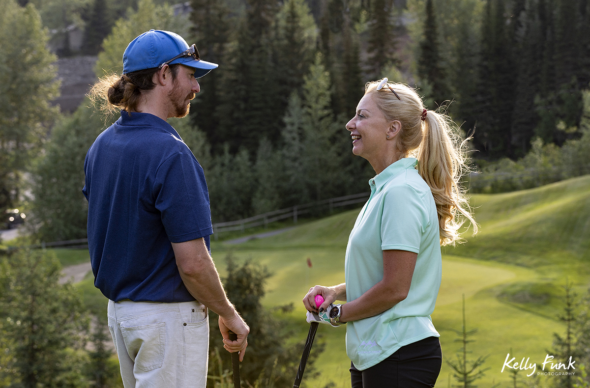 A couple talks about tee off approaches at the Sun Peaks Resort golf course, north east of Kamloops, British Columbia, Thompson Okanagan region, Canada