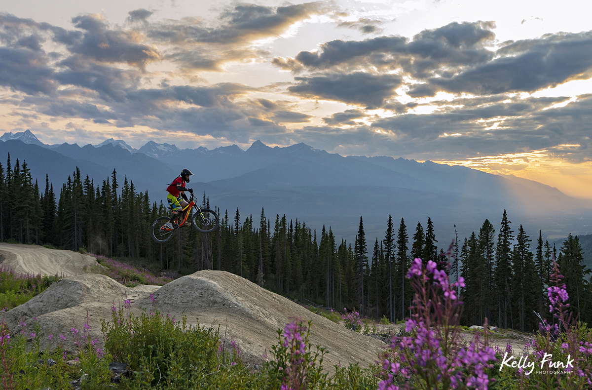 A single rider take on a rugged jump feature at sunset near the top of the bike park in Valemount, British Columbia, Canada
