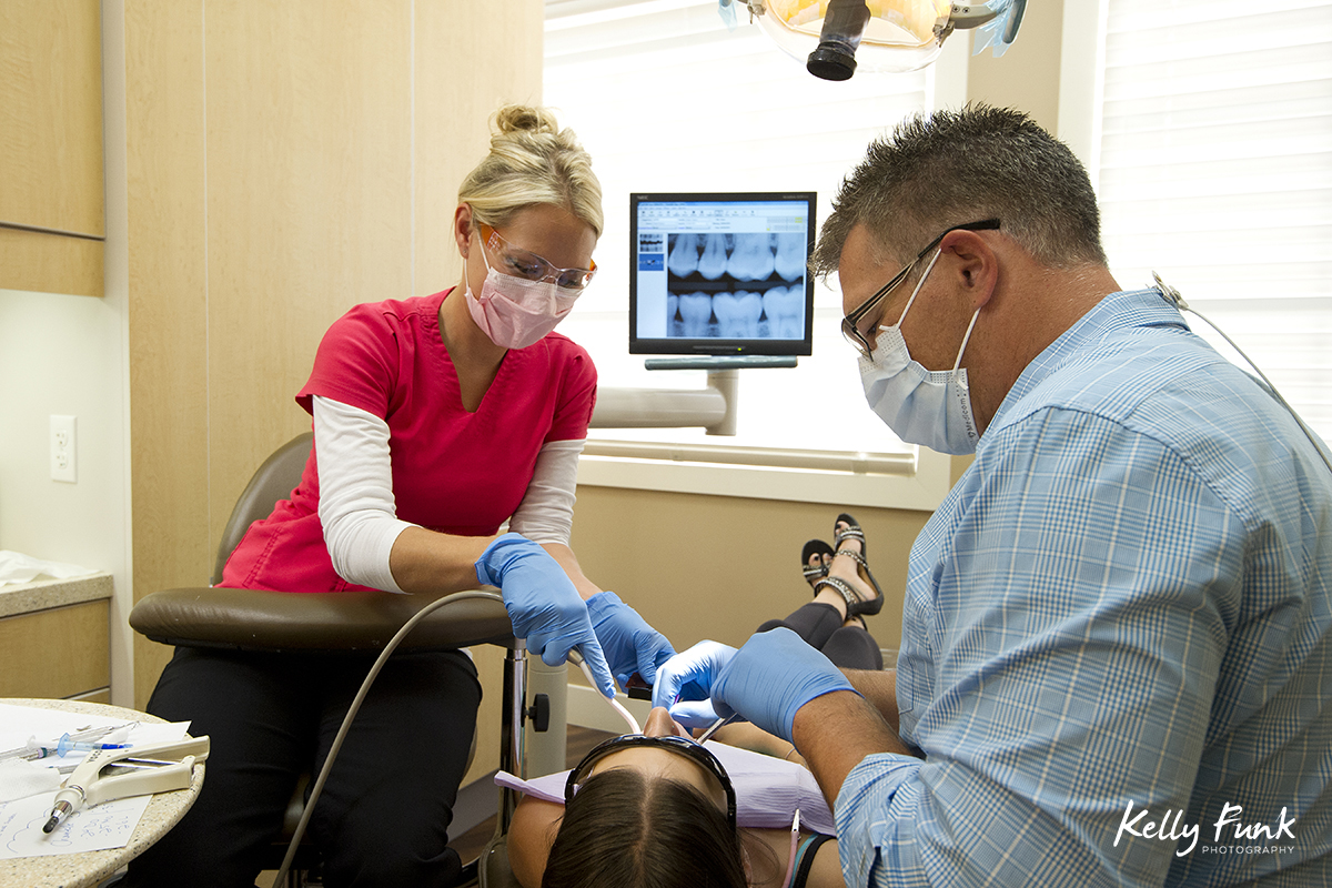 A dentist and assistant perform a procedure on a patient in Kelowna, British Columbia, Canada