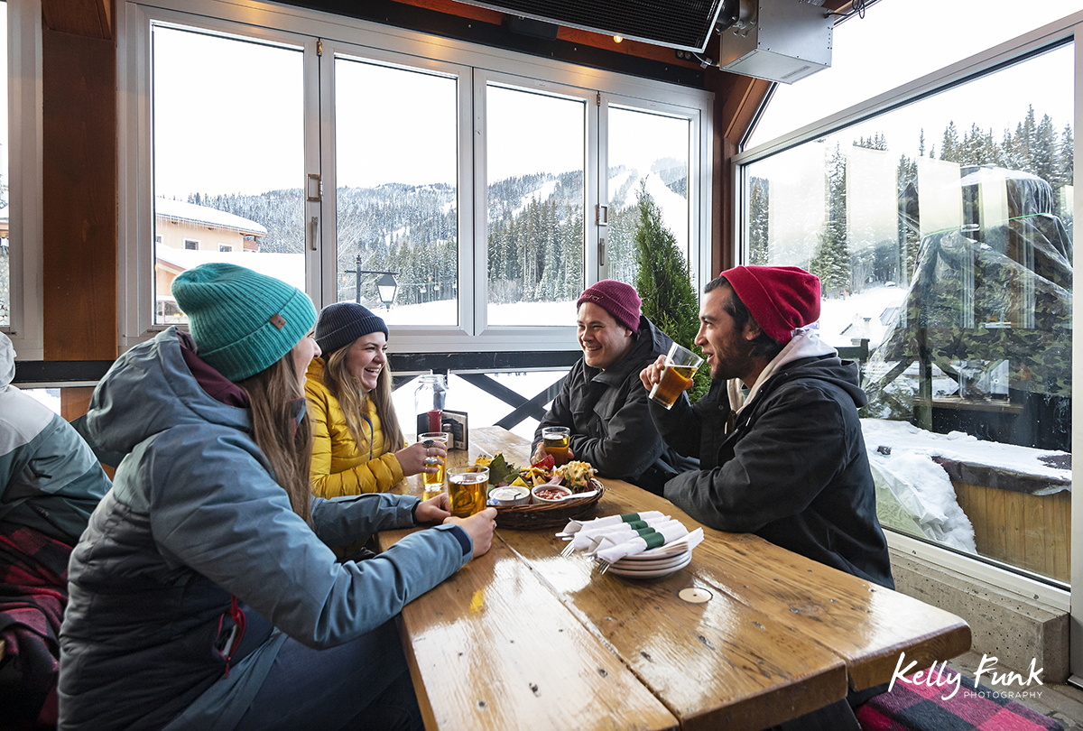 enjoying food and drinks after a ski day at the new Bottom's enclosed patio at Sun Peaks Resort during a tourism marketing shoot, British Columbia, Thompson Okanagan region, Canada