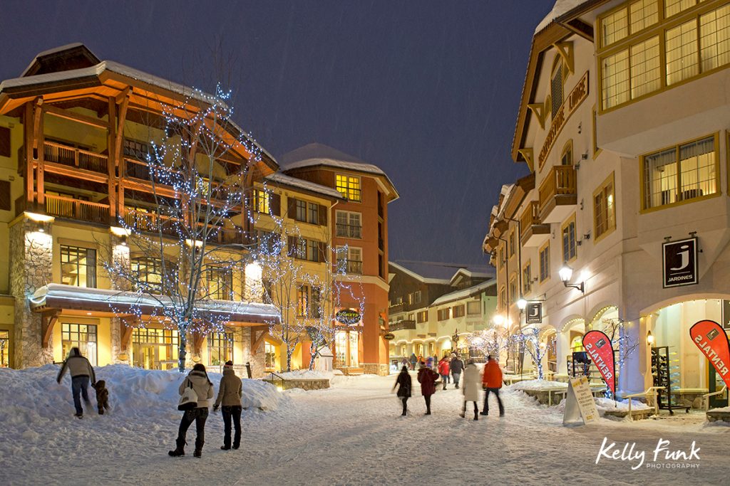 People make their way through the village of Sun Peaks on a beautiful, snowy evening, Thompson Okangan region, British Columbia, Canada